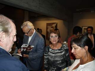 Jesús Núñez firmando ejemplares del catálogo de la exposición, a su lado Olga Patiño, escritora y poeta.